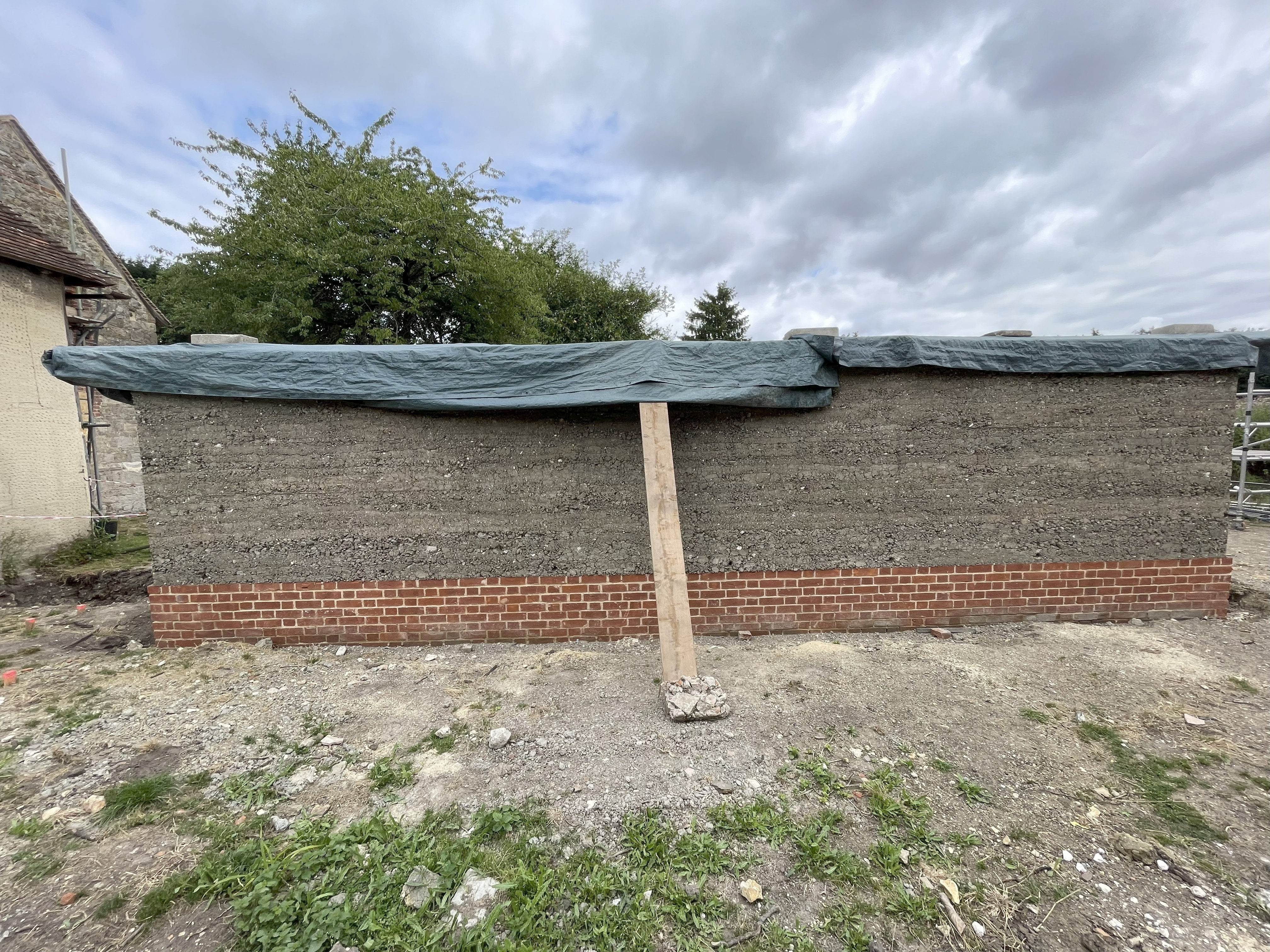 rammed earth wall with brick plinth
