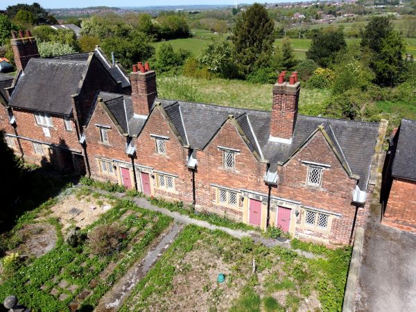 A row of small, red brick almshouses. 