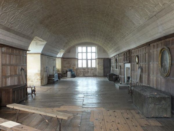 The Long Gallery at Chastleton house, with window floorboards, a domed ceiling and large window at the end. 