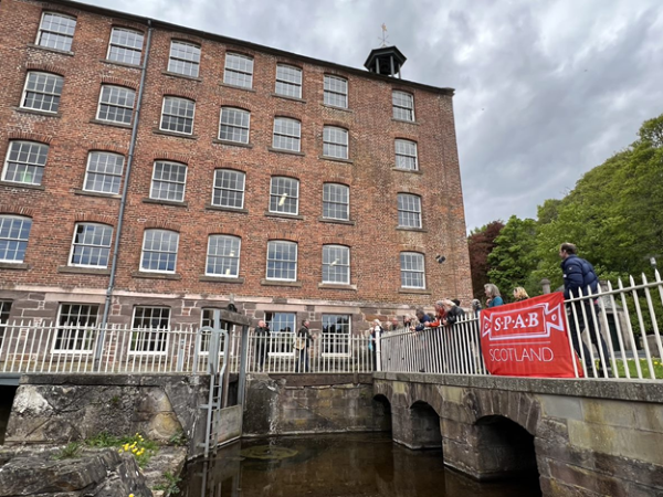 A group of SPAB delegates gathered on a bridge outside Stanley mills, overlooking the River Tay.