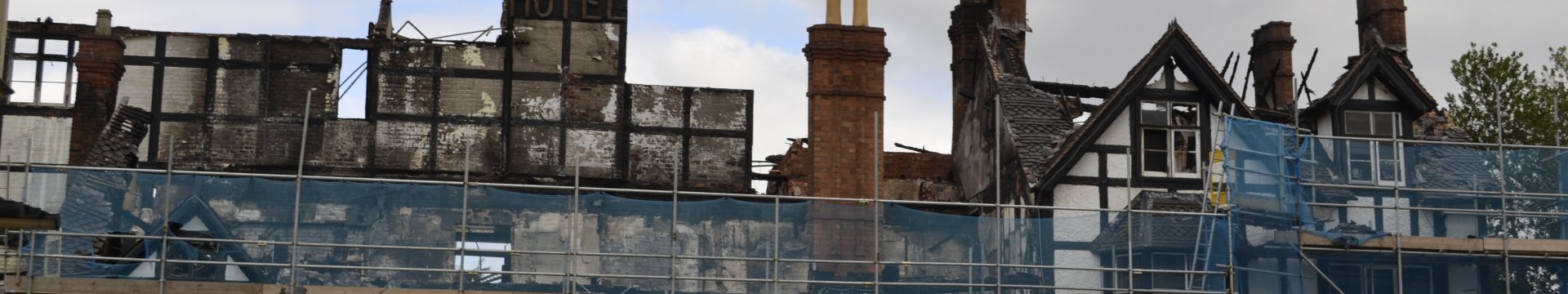 Raven Hotel after the fire. Burned out building behind construction barriers.