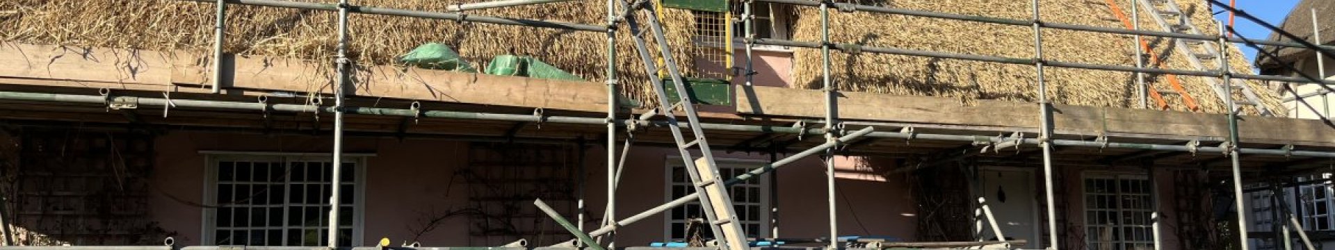 A thatched building with scaffolding up during the rethatching