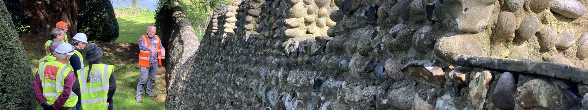 Lynn Mathias talking to course participants next to a flint wall, Hatfield House