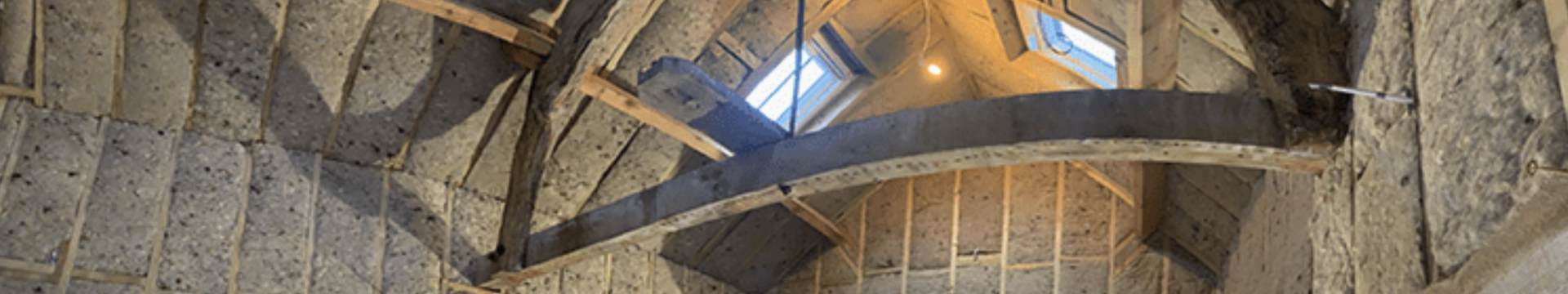 Sheep’s wool insulation batts fitted between rafters and timber studs within a historic roof structure, providing a breathable natural insulation solution as part of a retrofit project