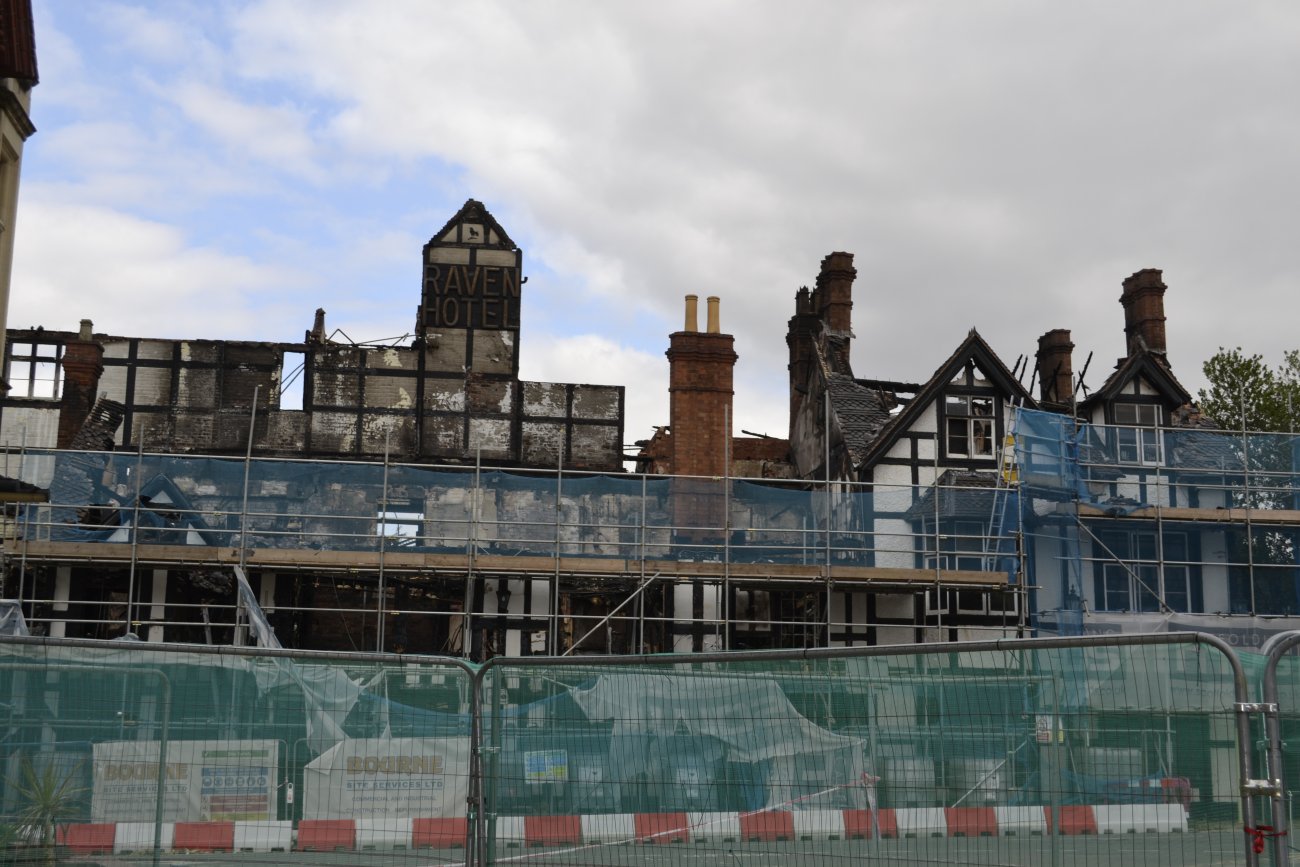 Raven Hotel after the fire. Burned out building behind construction barriers.