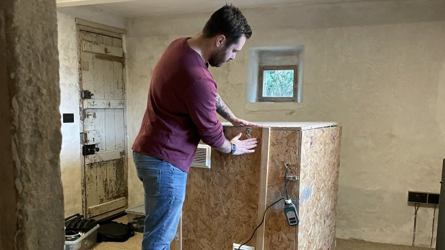 Working on the elemental cube system. A man with a large box with added vents and gadgets.