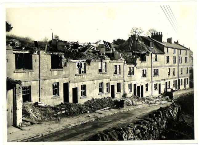 A row of ruined terraced houses. Sepia print
