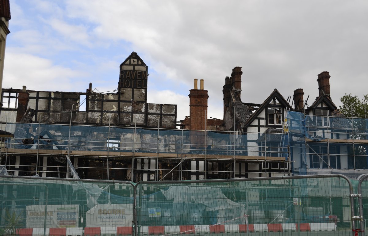 Raven Hotel after the fire. Burned out building behind construction barriers.