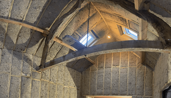 Sheep’s wool insulation batts fitted between rafters and timber studs within a historic roof structure, providing a breathable natural insulation solution as part of a retrofit project
